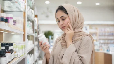 امرأة تبحث عن منتجات تسمين الوجه من الصيدلية مثل الكريمات والكولاجين والفيتامينات